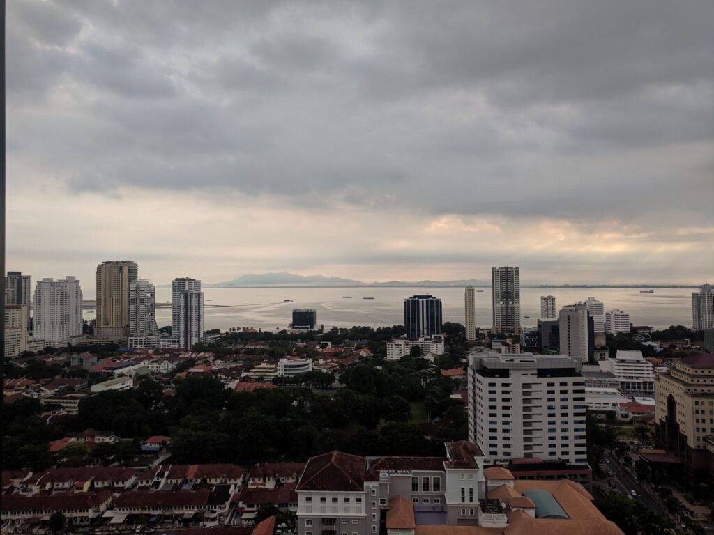 A view of a city with the ocean behind it