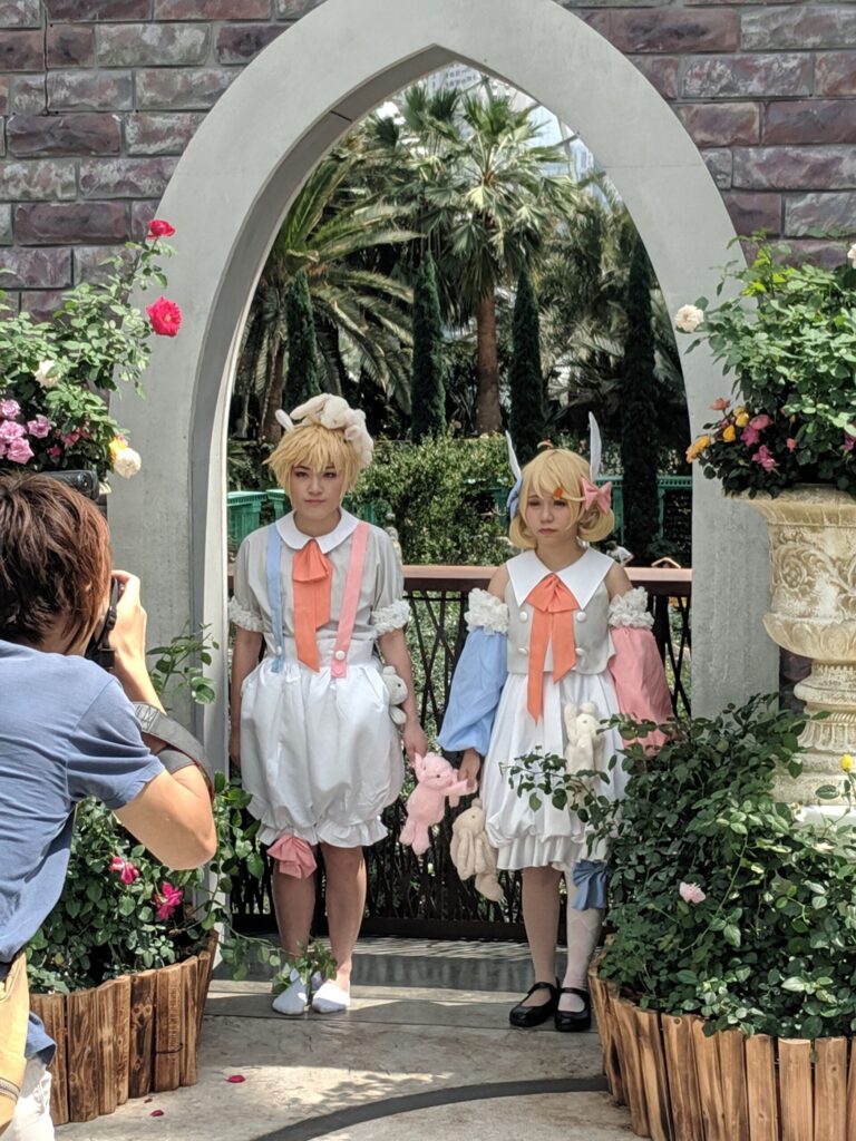Two young women dressed as elves posing in a garden