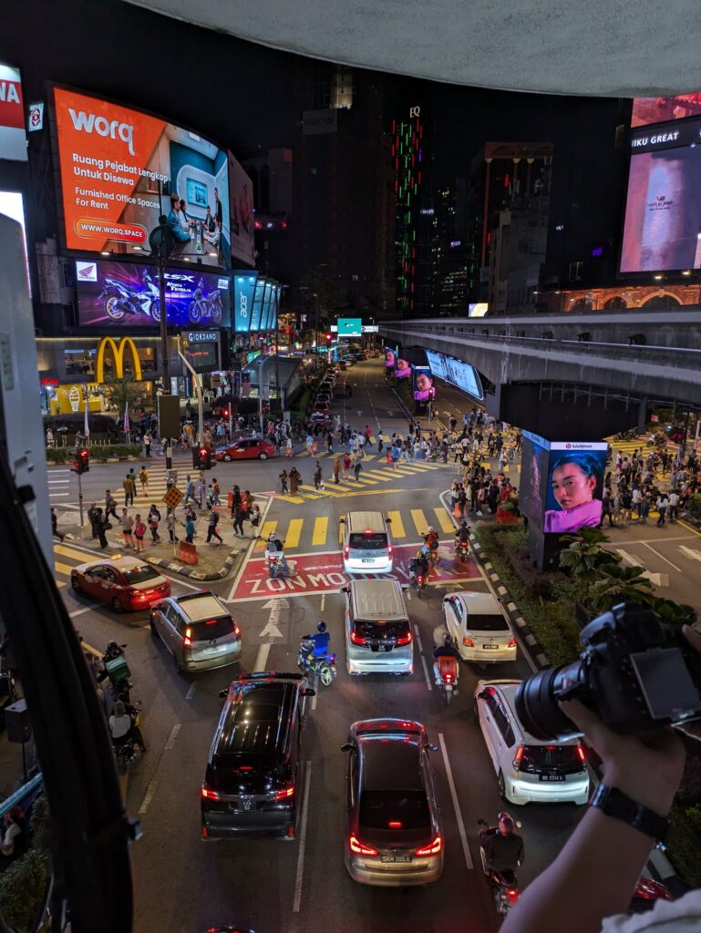 Night time scene from above with traffic and pedestrians being orderly and safe