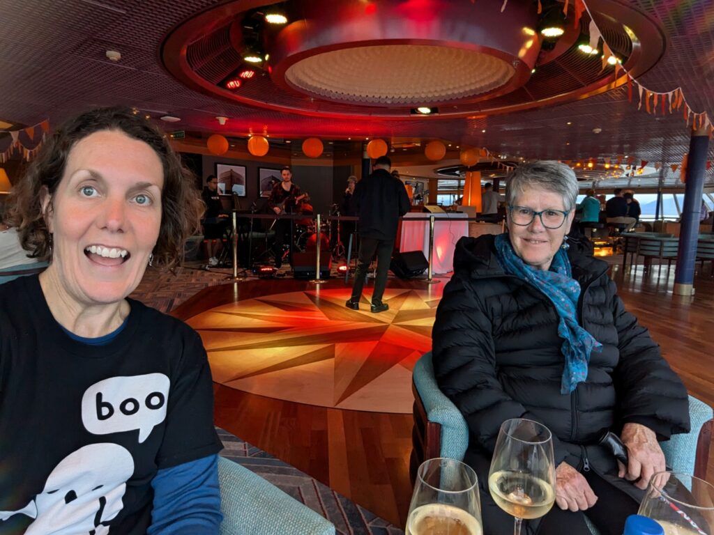 Two women sitting with a glass of wine in a bar
