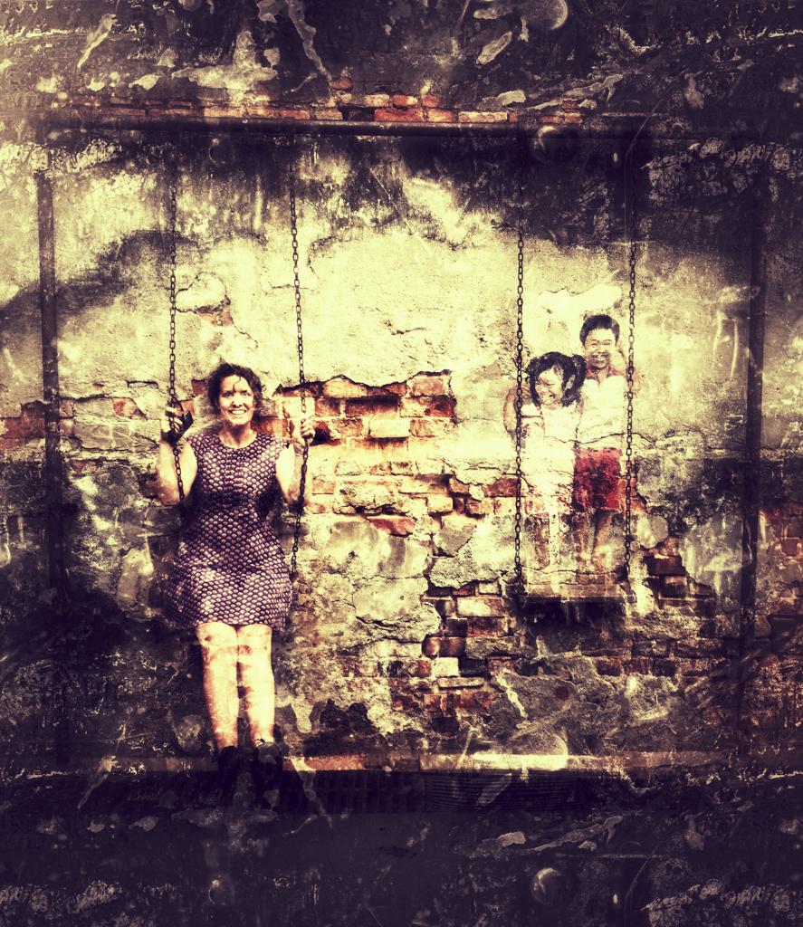 A wall mural depicting a woman and children on swings