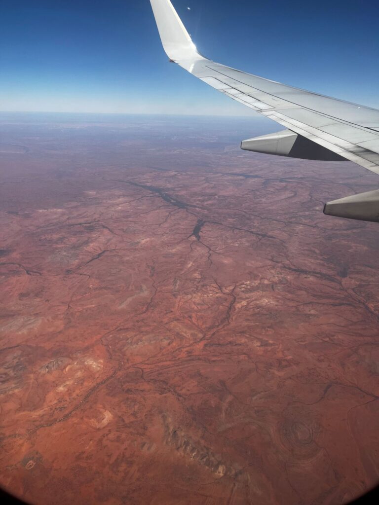 A view out of a plane on to a red desert landscape