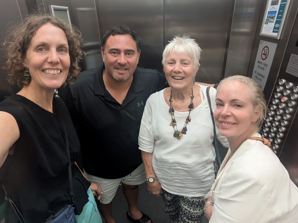 Four family members in an elevator smiling at the camera