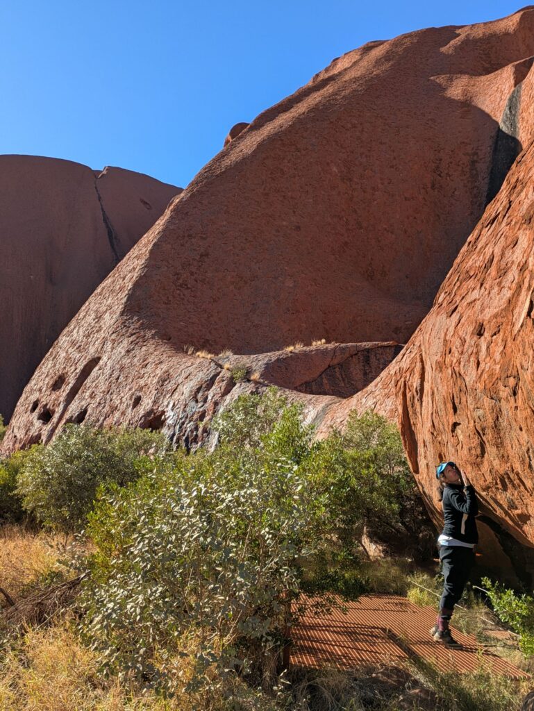 A woman hugging Uluru