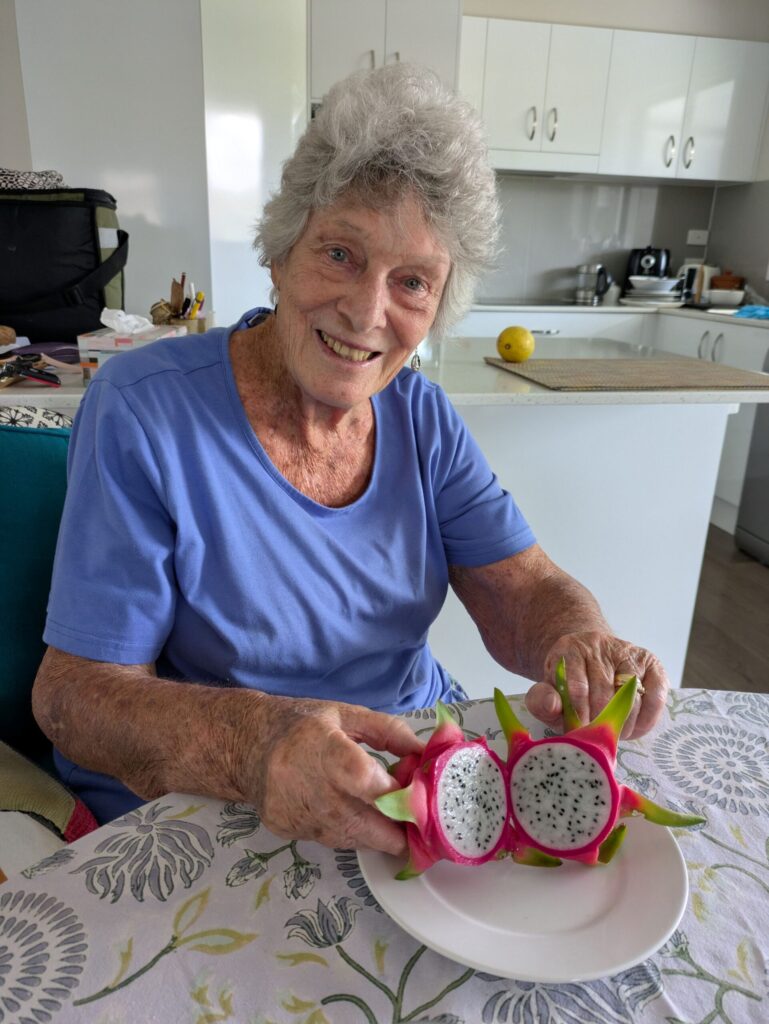 A woman showing a dragon fruit cut in half
