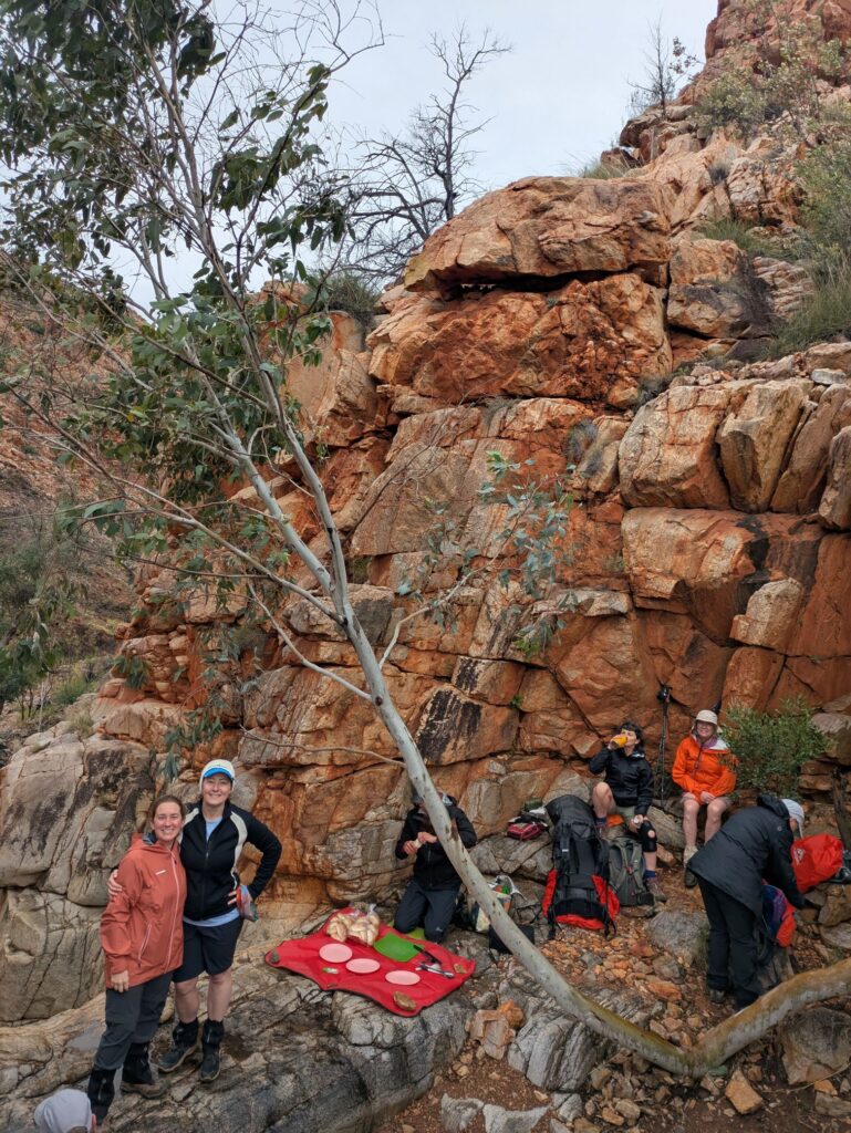 A tour group sitting around a rock