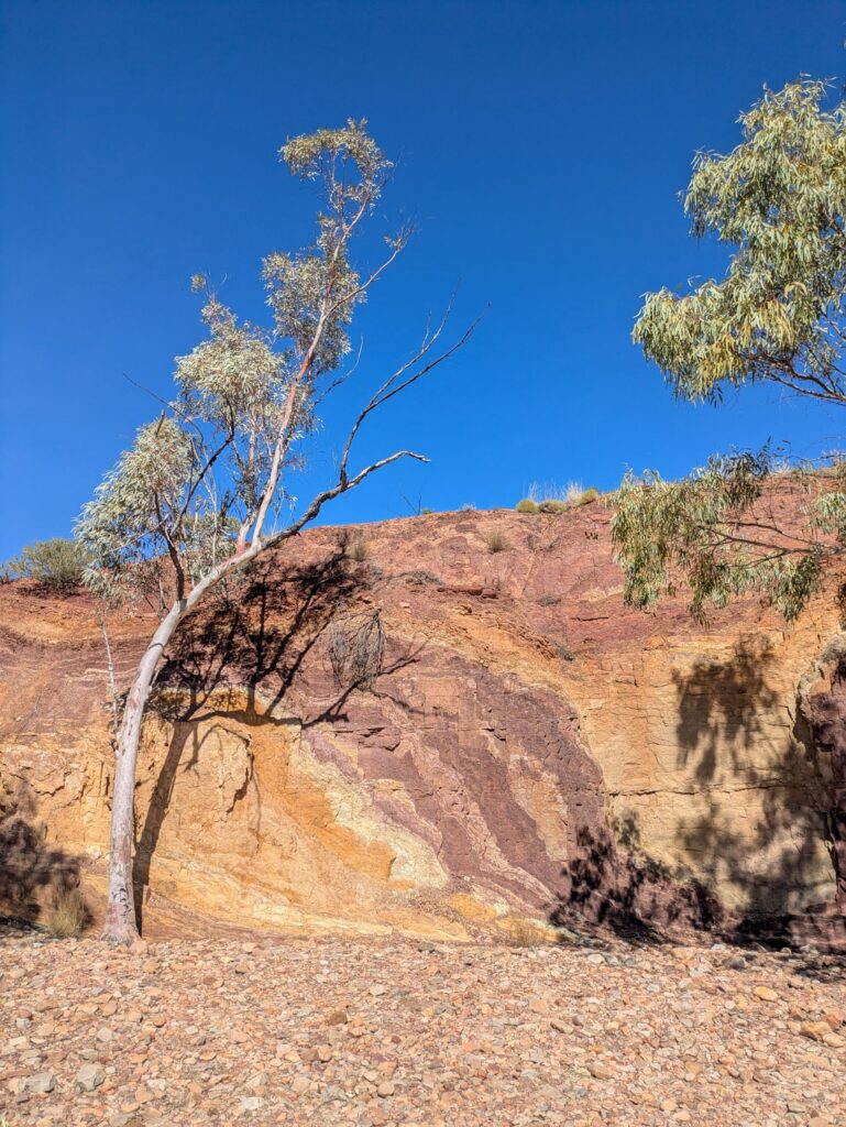 A rock wall featuring lines of colours of ochre