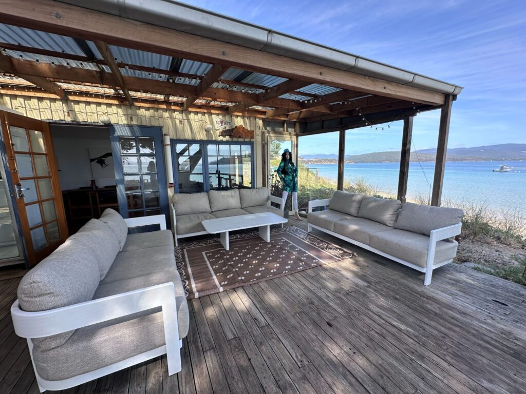 An outdoor entertaining area of a shack by the ocean with a mannequin in the corner to scare intruders